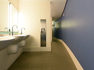 men's bathroom with three sinks and blue curving wall